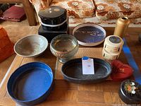Top-down photo capturing the full assortment of bowls and lacquerware on wooden table, showing various colors and designs.