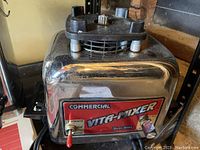 Front view of vintage Commercial Vita-Mixer Maxi 4000 showing red label, lever switch, and metal body.