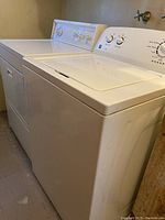 Kenmore washer and dryer side by side, showing clean white exterior and top surfaces.