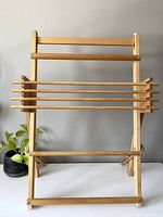 Front view showing the full standing loom with four horizontal rods and upright wooden frame