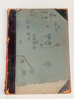 Front cover showing green cloth with black leather spine and corners, significant wear and spotting, spine loose