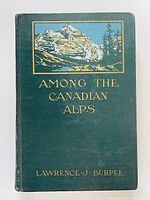 Front cover of the book showing green cloth with color mountain illustration and gold embossed text.