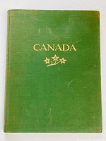 Front cover of the book showing green cloth cover with gold embossed title 'CANADA' and three stars below.