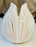 Front view of white bone china vase showing petal or leaf shape with peach and gold detailing.