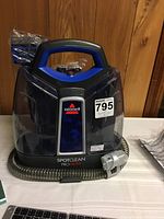 Front view of Bissell SpotClean ProHeat carpet cleaner showing model number 2694 and hose attachment.