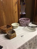 Photo displays all items on a white cloth table: two small Longaberger baskets, one small white floral decorated bowl, one large pale purple bowl with holes, two clear Pyrex glass bowls of different sizes.