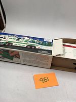 Partially open original box showing Hess gasoline tanker truck and helicopter toys inside. Small boxed accessories are included but not wrapped.