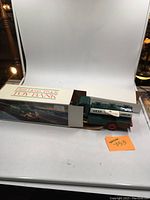 Photo showing 1985 Hess Truck Toy Bank in original box with green truck and gasoline tank design.