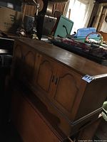 Side angle of wooden blanket chest showing paneled doors and wood finish