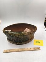 Front angled view of large Roseville Imperial ceramic vessel with ruler for scale, showing textured green and brown glaze.