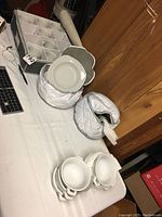 Photo of white ceramic Palm Restaurant bowls and storage containers, showing three bowls stacked and their rounded shapes with smooth edges.