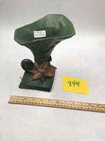 Front and top view of the green Roseville Clematis vase, showing flared opening and floral decoration.