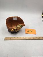 Photo showing Seashell conch-shaped planter with Water Lily pattern, ruler for scale, and lot tag