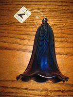 Blue bell-shaped art glass piece showing ruffled edge and Lundberg Studios tag.