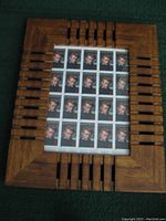 Full view of a sheet of James Dean postage stamps inside a decorative wooden frame with carved geometric design.