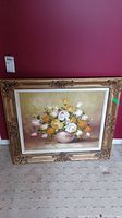 Full view of framed floral painting with a bouquet in a vase, showing overall presentation and minor defects in the frame.