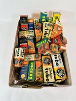 Overview of tray lot containing multiple old transistor tubes in original boxes with visible vintage branding from GE, Rogers, RCA, and others.