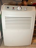 Front view of the Kenmore dehumidifier showing control panel with humidity control dial, fan speed selector, and Auto Shut-Off light.
