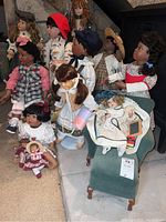 Group photo of 10 multicultural heirloom dolls in period dresses and accessories seated and standing around a green footstool