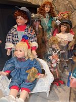 Heirloom dolls grouped together showing various styles including Native American, Christmas theme, boys and girls dolls.