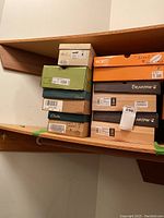 Photo of stacked shoe boxes including Bearpaw and Clarks. Various sizes 7 to 8 marked on boxes.