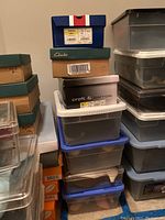 Stack of various women's shoe boxes and plastic storage bins containing footwear, showing branding including Croft & Barrow and Clarks.