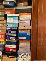 Photo of stacked shoe boxes indicating brands, sizes, and types of women's shoes in the lot.