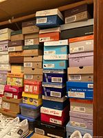 Stack of various shoe boxes with visible brands Clarks, Natural Soul, White Mountain, Ryka; mostly women's shoes sizes 7 to 7.5