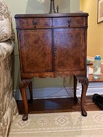 Front view of antique wood side table with cabinet doors and Queen Anne legs
