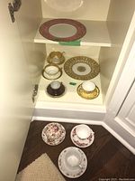 All pieces displayed inside cabinet on two shelves and floor