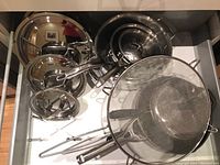 Drawer overview showing lids, pots, pans, shields and steamer basket