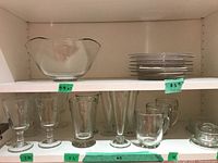Top shelf view: rectangular serving bowl on left, stack of round plates on right