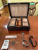 Open jewelry box showing suede-lined base and removable trays