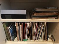 Shelf with binders and stacks of vintage and contemporary music scores and songbooks