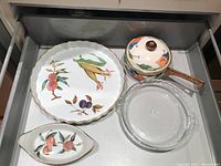 Drawer view showing the Evesham platter, enamel pot with floral pattern, Pyrex glass dish, and Evesham serving bowl.