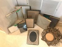 Photo of vintage photo frames showing various sizes and styles including metal and wood frames
