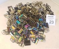 Pile of assorted multi-color metal key fob hardware pieces for making wristlets, lanyards, and keychains