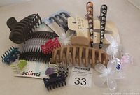 Photo showing assortment of large, medium, and small hair claws plus two painted floral hair clips.