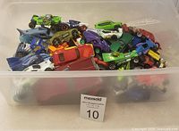 Plastic container filled with assorted small toy cars of various colors and designs