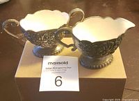 Two-piece silver-plated creamer and sugar set on a box, showing general size and shape
