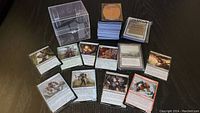 Overview of multiple stacks of Magic: The Gathering cards including sleeves, loose cards, and stacks.