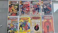 Photo of 8 Amazing Spider-Man comics laid out showing front covers with characters like Sabretooth, The Punisher, and Spider-Man in action scenes.