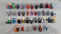 Photo showing 38 Marvel Lego minifigures lined up in rows, various characters including Thor, Hulk, Captain America, Iron Man, Spider-Man, Venom, Ghost Rider, Nova, and others.