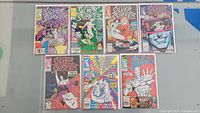 7 Silver Surfer comic books arranged in two rows on a flat surface, each bagged and boarded.
