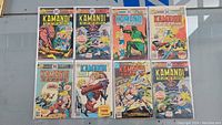 Eight Kamandi comic books laid out in two rows showing colorful cover art and wear consistent with heavy use.