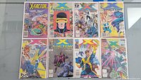 Lot of 8 Marvel X-Factor comic books spread out on a glass table showing front covers with colorful artwork and character illustrations mainly featuring Cyclops and other X-Men characters.