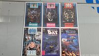 All six Batman comics laid out on a flat surface, showing a variety of covers including Joker pumpkin and Batman seated on chair.