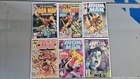 Photo showing front covers of six Iron Man comics #134, 144, 216, 238, 289, 327, arranged in two rows, bagged and boarded.
