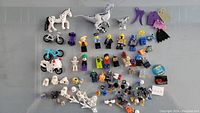 Top view of entire collection including two horses, two dinosaurs, multiple minifigure parts, bicycles, and accessories