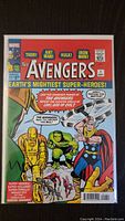 Photo of The Avengers #1 comic reprint cover showing Thor, Ant-Man, Hulk, and Iron Man in colorful artwork.